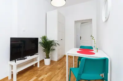 a living room with a white table and blue chairs at Apartment for two Krakowska 16 Street in Kraków