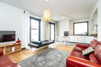 a living room with a red couch and a kitchen at RentPlanet - Kamienica Retmana in Kraków