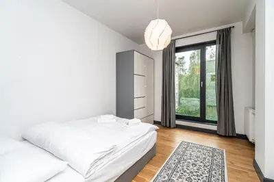 a bedroom with two beds and a large window at RentPlanet - Kamienica Retmana in Kraków