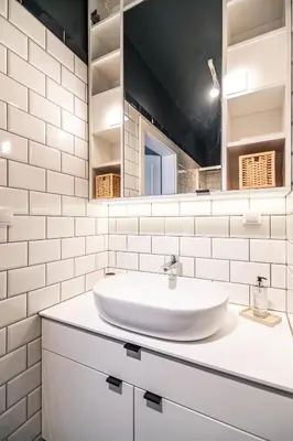 a white bathroom with a sink and a mirror at RentPlanet - Kamienica Retmana in Kraków