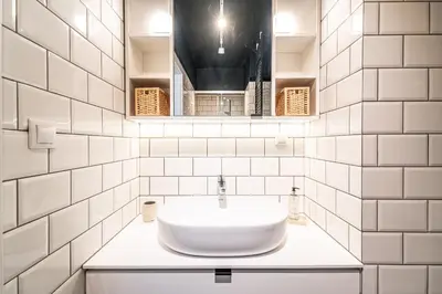 a white bathroom with a sink and a mirror at RentPlanet - Kamienica Retmana in Kraków
