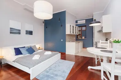 a living room with a bed and a dining room at Main Square Apartment - Old Town in Kraków