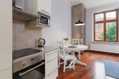 a kitchen with a table and a small table with chairs at Main Square Apartment - Old Town in Kraków