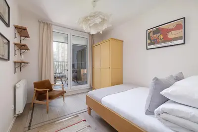 a bedroom with a bed and a chair and a window at Apartment with Balcony - Masarska 8 Street in Kraków