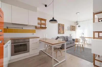 a kitchen and living room with a table and a couch at Apartment with Balcony - Masarska 8 Street in Kraków