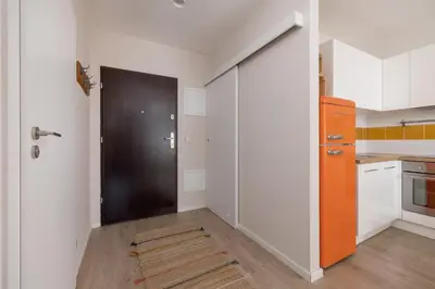 an empty kitchen with an orange door in a room at Apartment with Balcony - Masarska 8 Street in Kraków