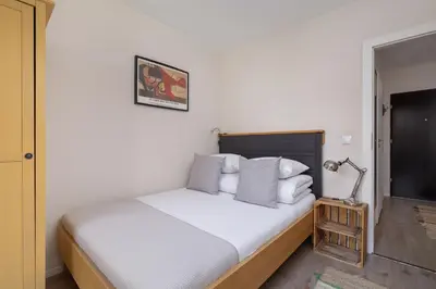a bedroom with a bed with white sheets and pillows at Apartment with Balcony - Masarska 8 Street in Kraków