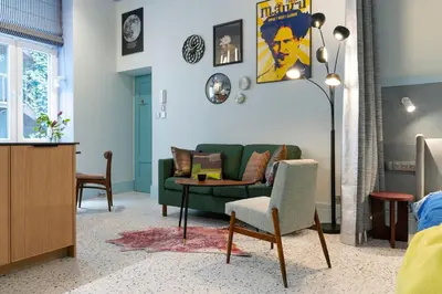 a living room with a green couch and a table at Dietla 11 - Art Studio for 2 in Kraków