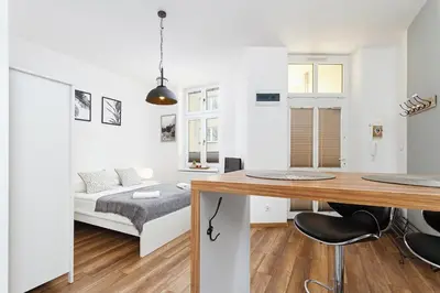 a white apartment with a desk and a bed at Charming Studio - 54 Starowislna street in Kraków