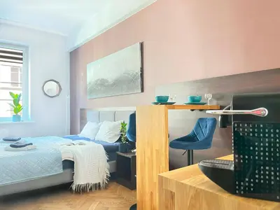 a bedroom with a bed and a blue chair at Well-connected Apartment in Old Town Cracow in Kraków