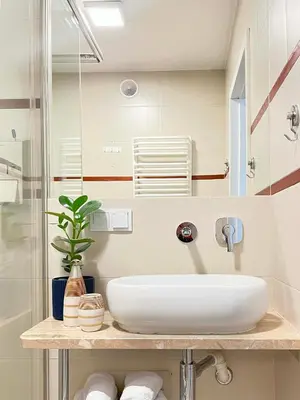 a bathroom with a white sink and a shower at Well-connected Apartment in Old Town Cracow in Kraków