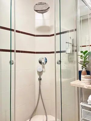 a shower with a glass door in a bathroom at Well-connected Apartment in Old Town Cracow in Kraków
