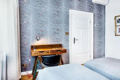 a bedroom with a desk in front of a wall with a bed at STAR66 Apartment, Air-cond in Kraków