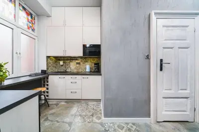 a kitchen with white cabinets and a white door at STAR66 Apartment, Air-cond in Kraków