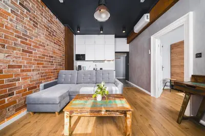 a living room with a couch and a brick wall at STAR66 Apartment, Air-cond in Kraków