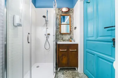 a bathroom with a shower and a blue door at STAR66 Apartment, Air-cond in Kraków