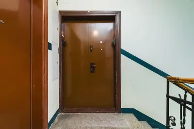 a brown door in a hallway with a staircase at STAR66 Apartment, Air-cond in Kraków