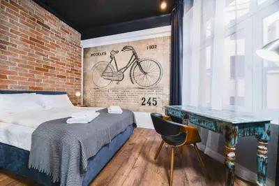 a bedroom with a brick wall and a bed and a desk at STAR66 Apartment, Air-cond in Kraków
