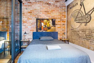 a bedroom with a blue bed and a brick wall at STAR66 Apartment, Air-cond in Kraków