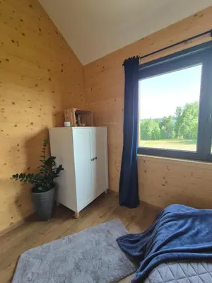 a wooden house with a balcony on a field at Natur House Beskidy - dom z drzewa księżycowego z SAUNĄ i BALIĄ Jacuzzi!! in Ślemień