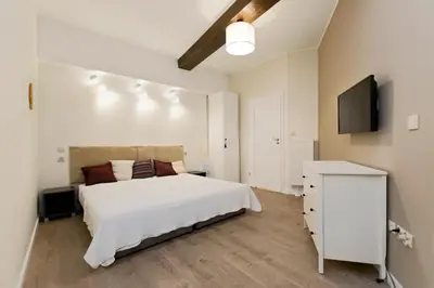 a bedroom with a white bed and a television at Jewish Quarter - 54 Starowiślna Street in Kraków
