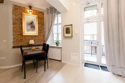 a dining room with a table and a brick wall at Jewish Quarter - 54 Starowiślna Street in Kraków