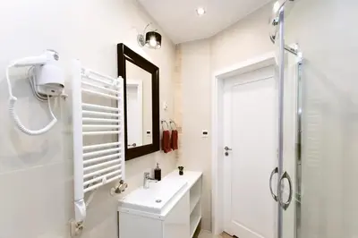 a white bathroom with a sink and a shower at Jewish Quarter - 54 Starowiślna Street in Kraków