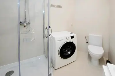 a washing machine in a bathroom with a toilet at Jewish Quarter - 54 Starowiślna Street in Kraków