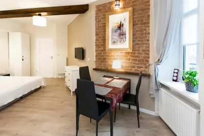 a room with a table and a bed and a bedroom at Jewish Quarter - 54 Starowiślna Street in Kraków
