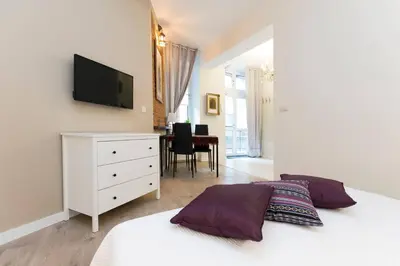 a bedroom with a bed and a tv on a wall at Jewish Quarter - 54 Starowiślna Street in Kraków