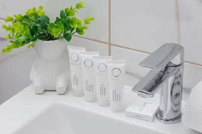 a white bathroom sink with a faucet and a plant at Stylish Apartment near Tauron Arena by Rent like home in Kraków