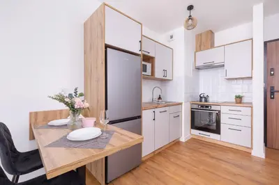 a kitchen with a wooden table and a dining room at Stylish Apartment near Tauron Arena by Rent like home in Kraków