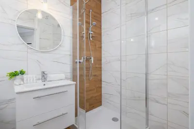 a white bathroom with a shower and a sink at Stylish Apartment near Tauron Arena by Rent like home in Kraków