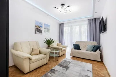 a living room with two chairs and a table at APARTAMENT PARKOWY UL. RACLAWICKA in Kraków
