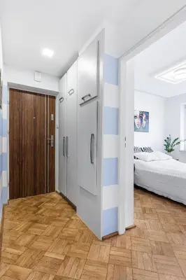a kitchen with a refrigerator in a room with a bed at APARTAMENT PARKOWY UL. RACLAWICKA in Kraków