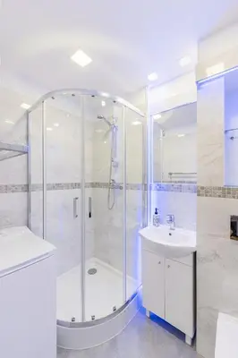 a white bathroom with a shower and a sink at APARTAMENT PARKOWY UL. RACLAWICKA in Kraków