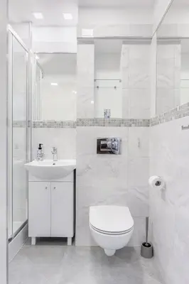 a white bathroom with a toilet and a sink at APARTAMENT PARKOWY UL. RACLAWICKA in Kraków