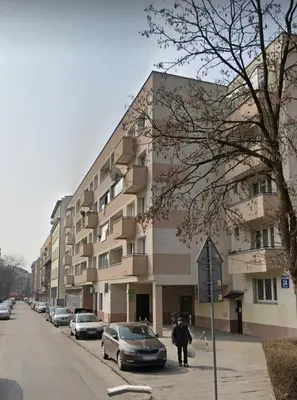 a building on the side of a street with parked cars at APARTAMENT PARKOWY UL. RACLAWICKA in Kraków