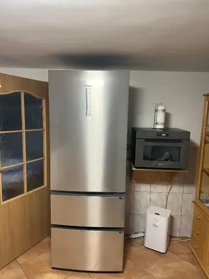 a stainless steel refrigerator in a kitchen with a microwave at Apartament u Moni in Sucha Beskidzka