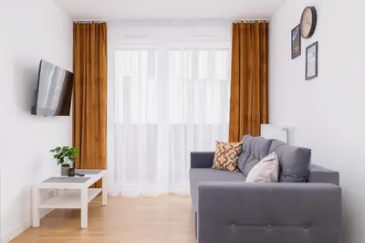 a living room with a blue couch in front of a window at Modern Apartment with Parking near Tauron Arena by Rent like home in Kraków
