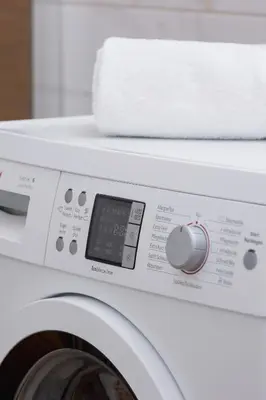 a white washing machine with a towel on top of it at Modern Apartment with Parking near Tauron Arena by Rent like home in Kraków