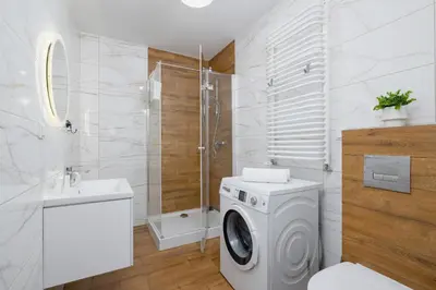 a bathroom with a washing machine and a shower at Modern Apartment with Parking near Tauron Arena by Rent like home in Kraków