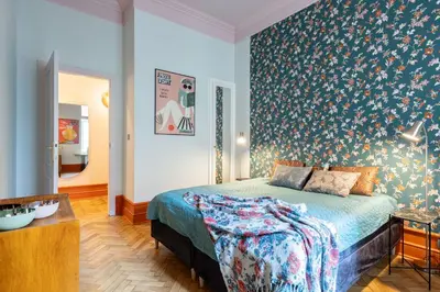 a bedroom with a bed with a floral wallpaper at Two bedroom apartment-Dietla 11- Wawel Castle view in Kraków