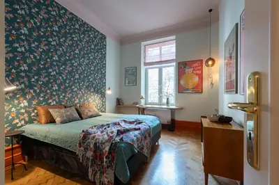 a bedroom with a bed and a wall covered in wallpaper at Two bedroom apartment-Dietla 11- Wawel Castle view in Kraków
