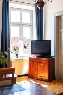a living room with a flat screen tv on a wooden cabinet at Vista View Apartment in Kraków