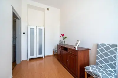 a room with a chair and a dresser and a window at Vista View Apartment in Kraków