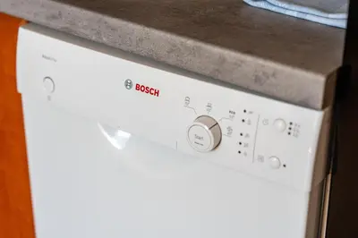 a white dishwasher with the word design on it at Vista View Apartment in Kraków