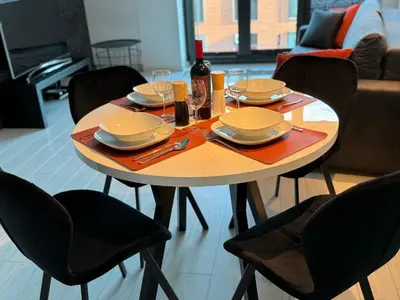 a table with plates and glasses on top of it at Black&White Angel Apartment in Kraków