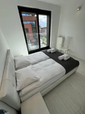 a large bed in a room with a large window at Black&White Angel Apartment in Kraków