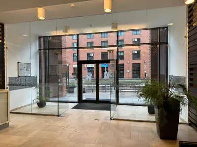 an open glass door in a building with two potted plants at Black&White Angel Apartment in Kraków
